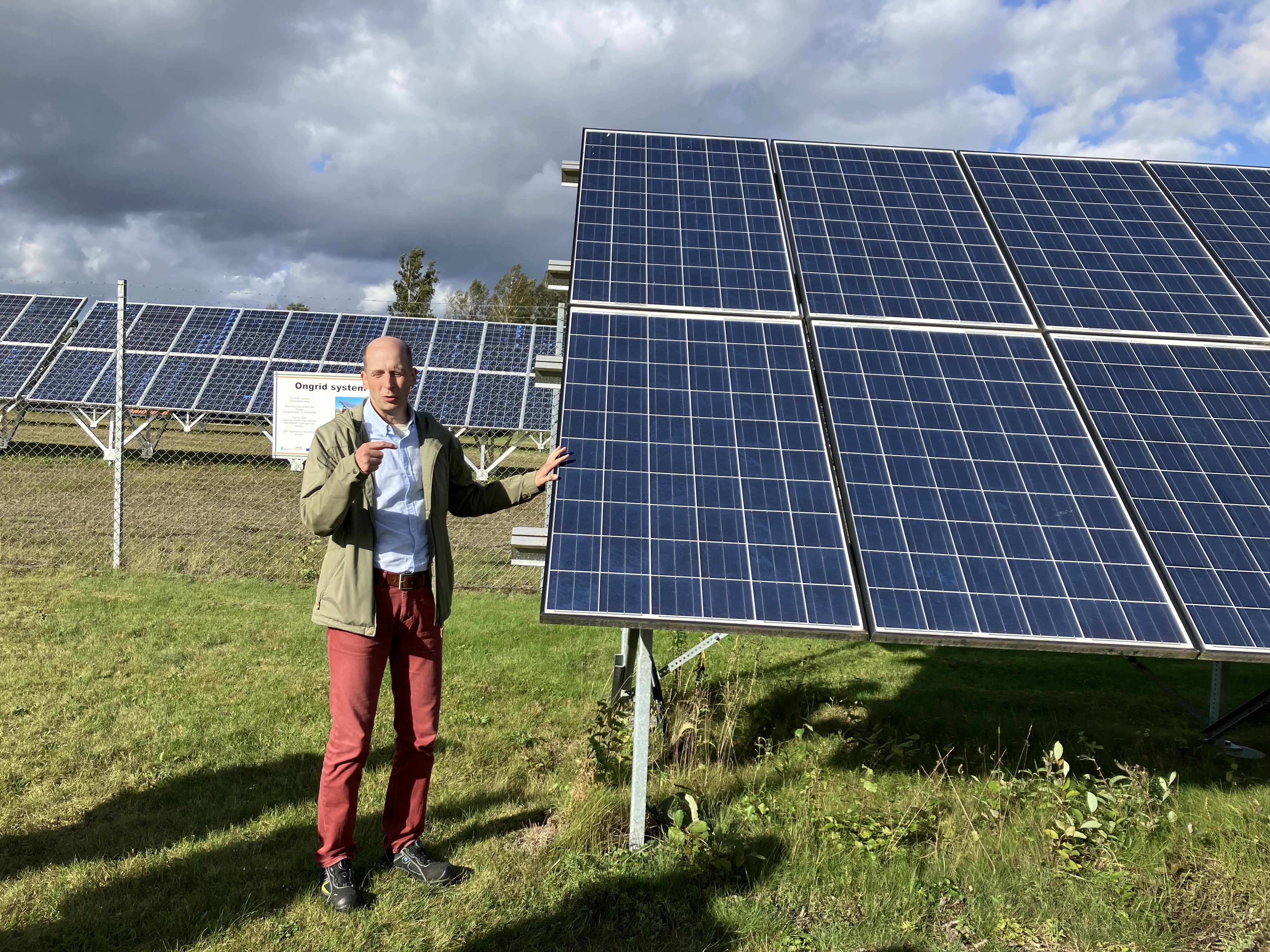 Man pratar framför solceller